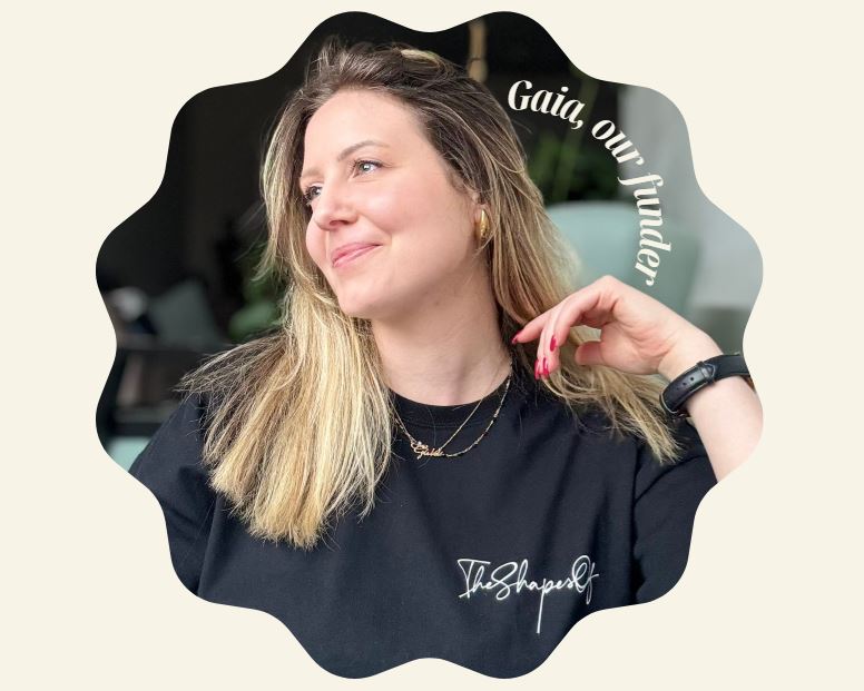 Woman wearing a black sweatshirt with text, standing outdoors.